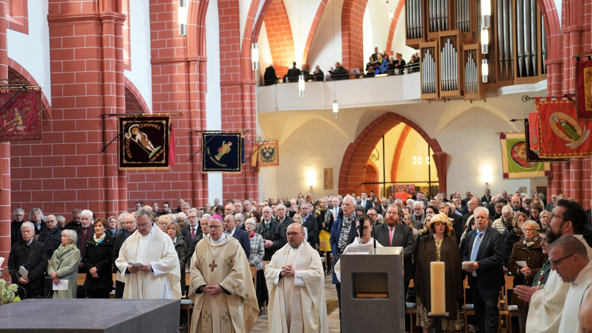 Während der Allerheiligenlitanei zur Weihe des neuen Altars stehen Pfr. Hans-Günther Ullrich, Bischof Ackermann, Pfr. Markus Nicolay vor der Altarinsel, die Gottesdienstgemeinde mit Oberbürgermeister Wolfram Leibe, Kulturdezernent Markus Nöhl und Baudezernent Andreas Ludwig stehen hinter ihnen.
