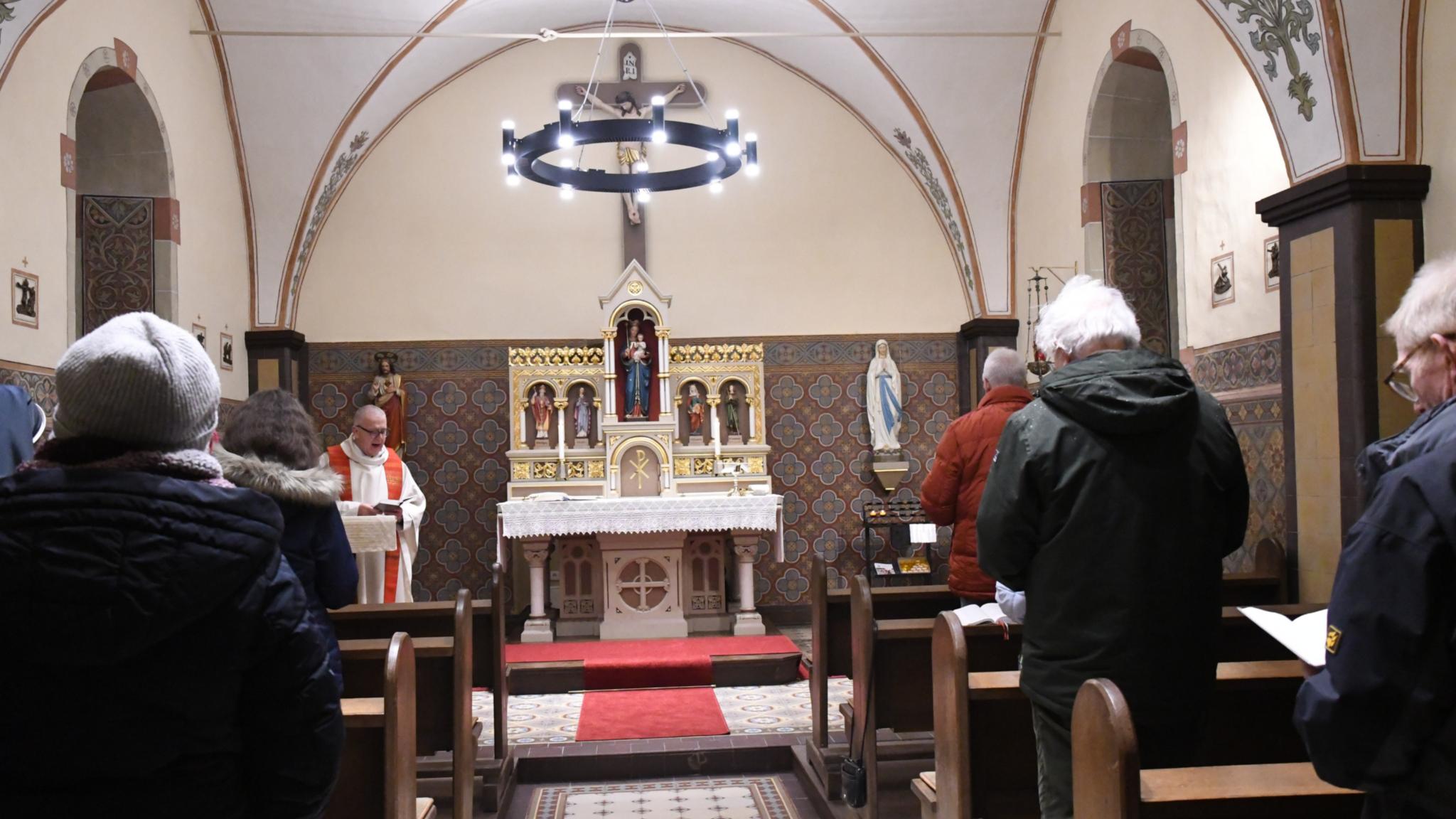 Auch im Winter gerne Gottesdienst feiern: Die Heizung unter anderem in den Lampen der Kapelle in Bitburg-Stahl wärmt bei ungemütlichen Außentemperaturen die Gemeinde auf.