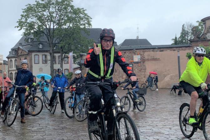 Viele Radfahrer, die im Regen ihre Runden um den Trierer Dom drehen.