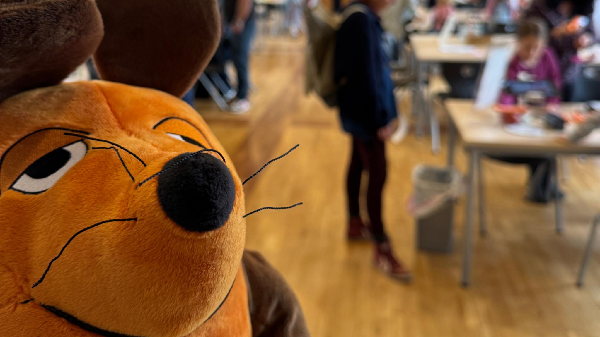 Die Maus ist zu sehen und im Hintergrund Menschen